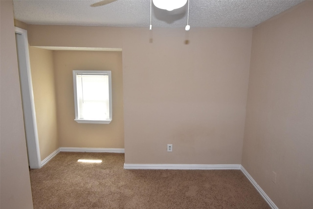 unfurnished room featuring baseboards, carpet, and a textured ceiling