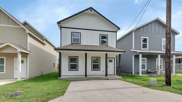 view of front of house with board and batten siding, a front yard, and covered porch