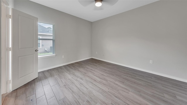 empty room featuring baseboards, a ceiling fan, and wood finished floors