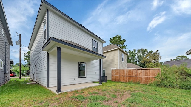 back of property with a lawn, central AC unit, fence, and a patio
