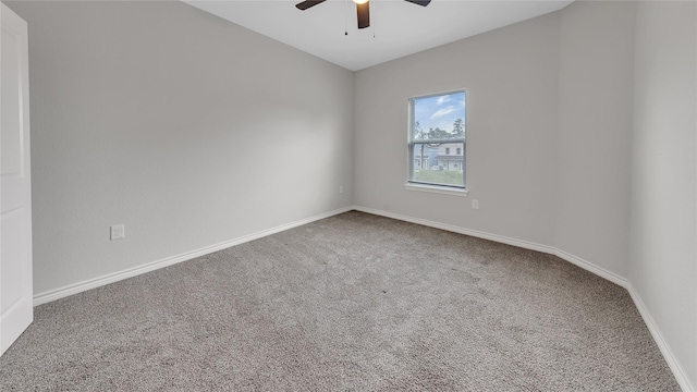 carpeted empty room featuring baseboards and ceiling fan