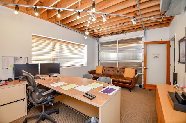 carpeted home office with beam ceiling