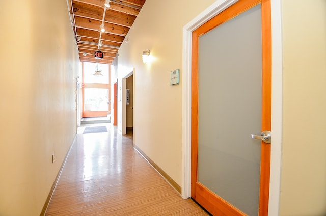 hall with a wealth of natural light, light hardwood / wood-style flooring, and wood ceiling