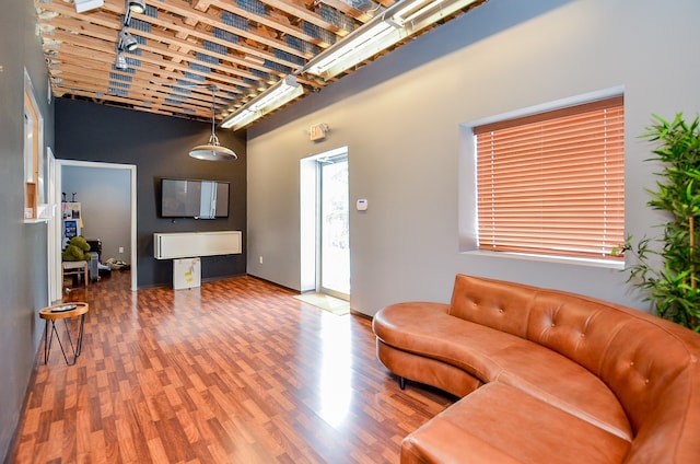 living room featuring hardwood / wood-style flooring and a towering ceiling