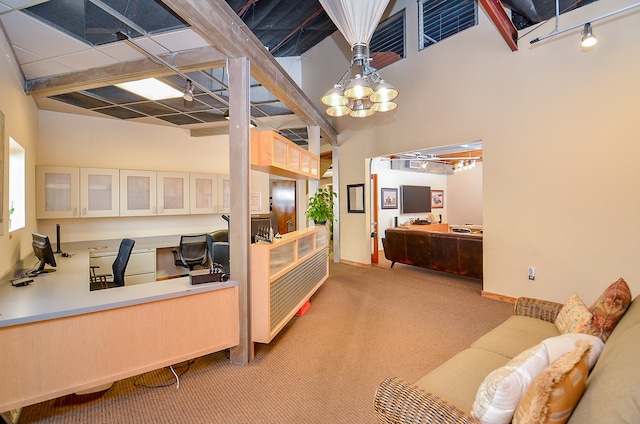 interior space with a towering ceiling, a chandelier, and carpet