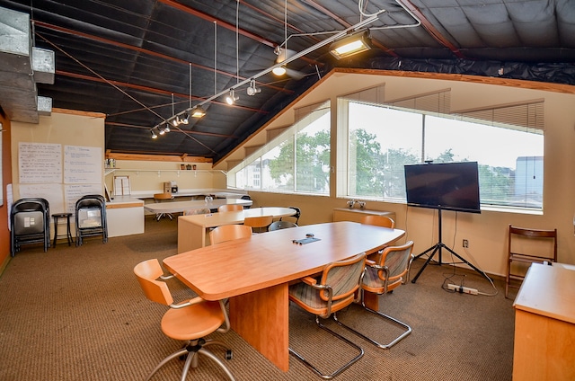 carpeted dining area with lofted ceiling