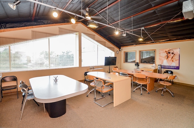 carpeted dining area with vaulted ceiling