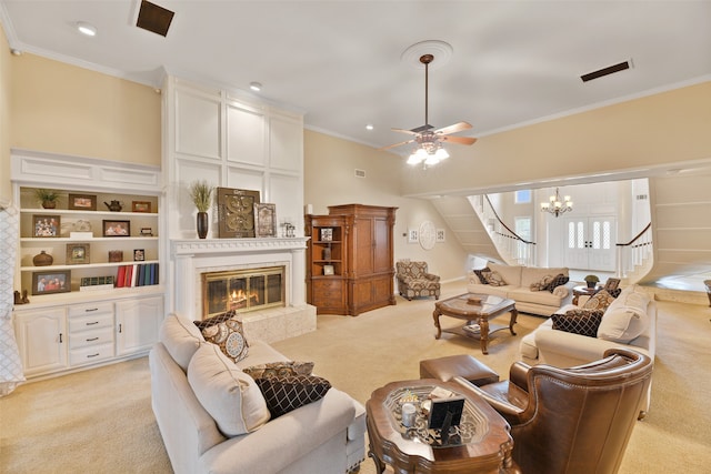 living room featuring ceiling fan with notable chandelier, crown molding, and light colored carpet