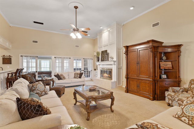 living room with crown molding, a high ceiling, and ceiling fan