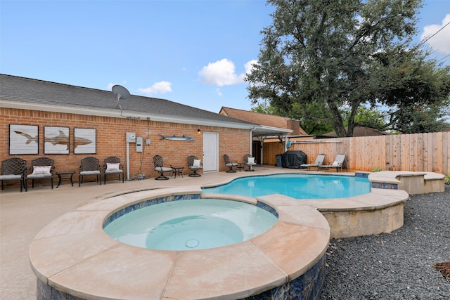 view of swimming pool featuring a patio and an in ground hot tub