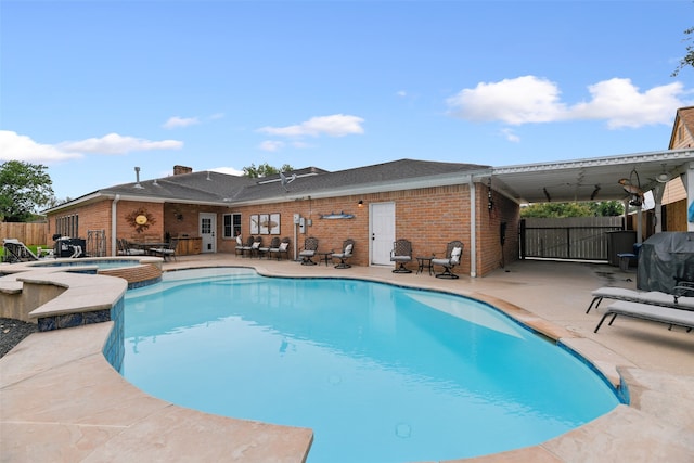 view of swimming pool with a grill, an in ground hot tub, and a patio