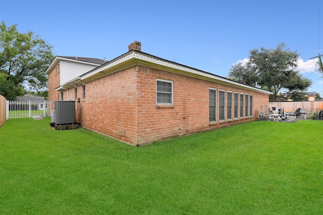 back of house featuring a yard and cooling unit