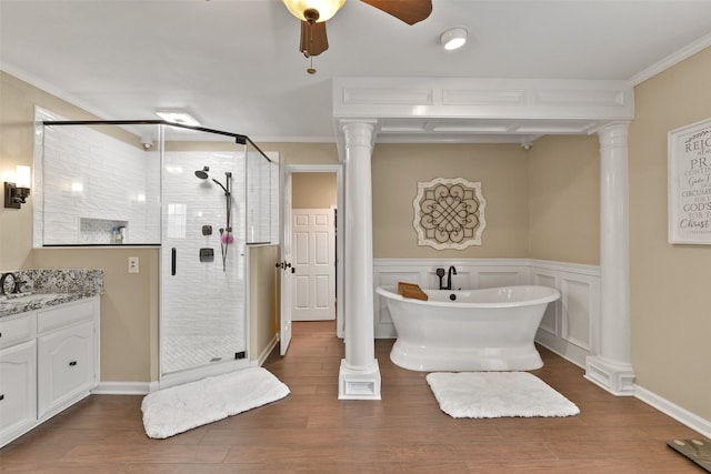 bathroom with plus walk in shower, hardwood / wood-style floors, crown molding, and vanity