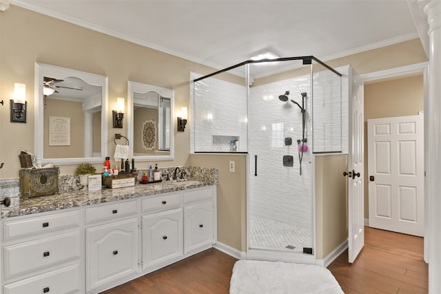 bathroom featuring a shower with shower door, vanity, hardwood / wood-style floors, ornamental molding, and ceiling fan