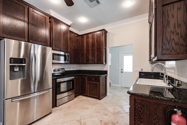 kitchen with a textured ceiling, ornamental molding, sink, and stainless steel appliances