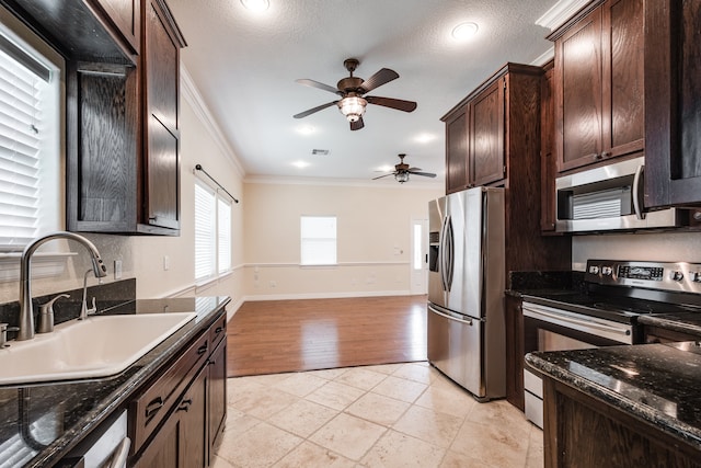 kitchen featuring ceiling fan, ornamental molding, sink, appliances with stainless steel finishes, and light hardwood / wood-style floors