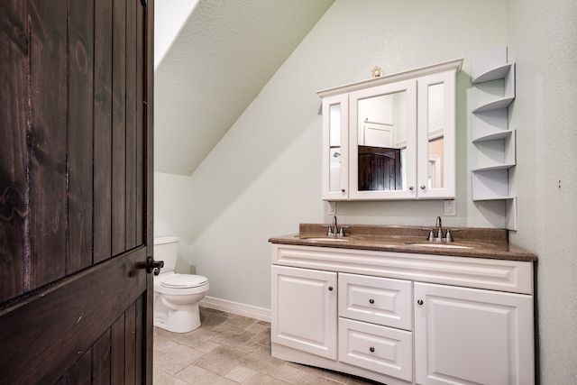 bathroom with vanity, lofted ceiling, and toilet