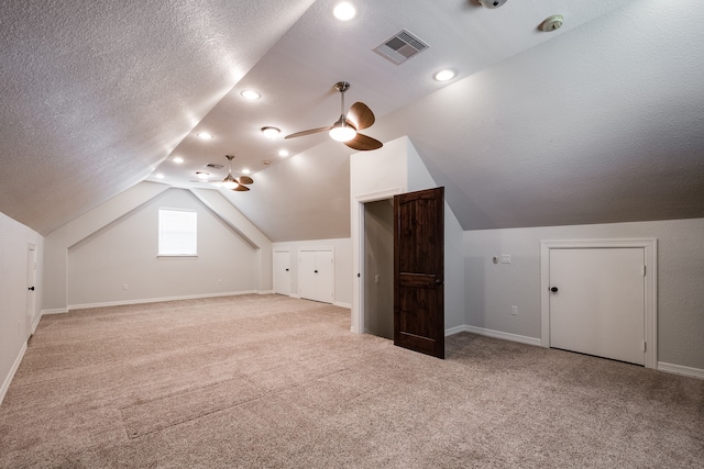 bonus room featuring ceiling fan, light colored carpet, a textured ceiling, and lofted ceiling