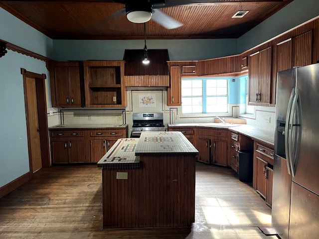 kitchen with light wood-type flooring, appliances with stainless steel finishes, tasteful backsplash, a kitchen island, and wood ceiling