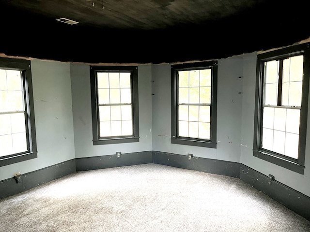 carpeted spare room featuring plenty of natural light