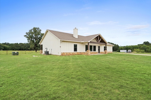 rear view of house with a yard and central AC unit