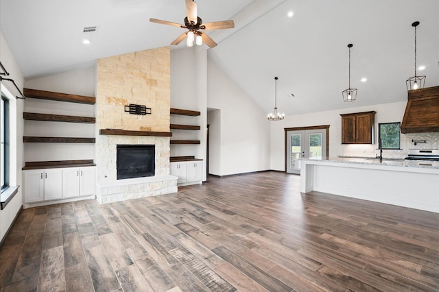 unfurnished living room featuring ceiling fan, french doors, high vaulted ceiling, dark hardwood / wood-style floors, and a fireplace