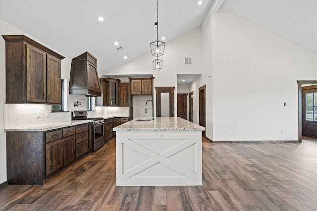 kitchen with stainless steel gas stove, dark hardwood / wood-style floors, high vaulted ceiling, and custom exhaust hood