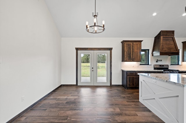 kitchen featuring custom exhaust hood, dark wood-type flooring, french doors, light stone countertops, and stainless steel range oven