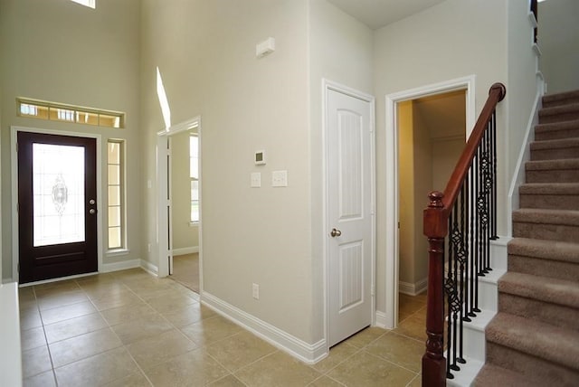 foyer with light tile patterned floors and a towering ceiling