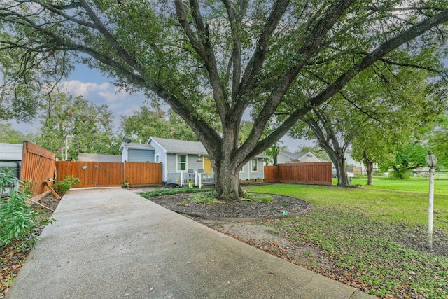 exterior space with driveway, a front lawn, and fence