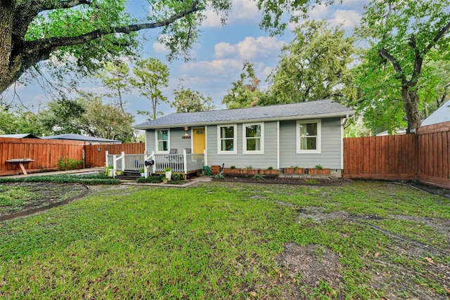 single story home with a wooden deck and a front lawn