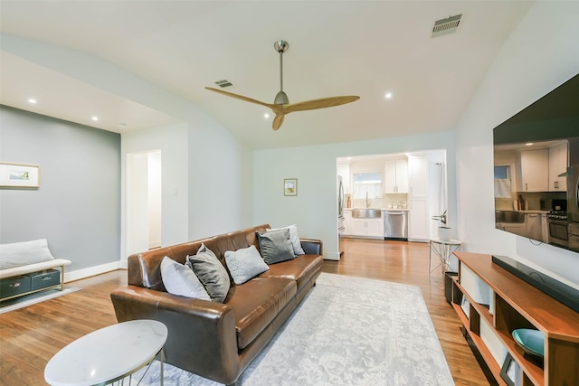 living room featuring light hardwood / wood-style flooring, ceiling fan, lofted ceiling, and sink