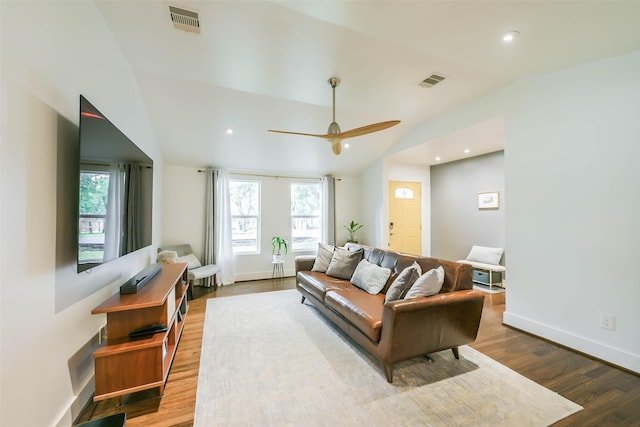 living room with ceiling fan, light hardwood / wood-style floors, and vaulted ceiling