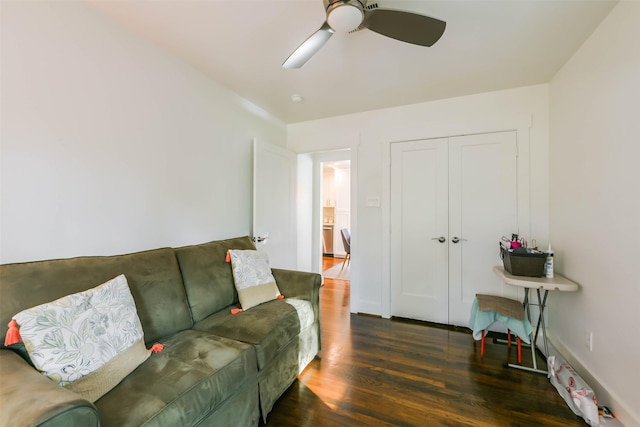 living room featuring ceiling fan and dark wood-type flooring