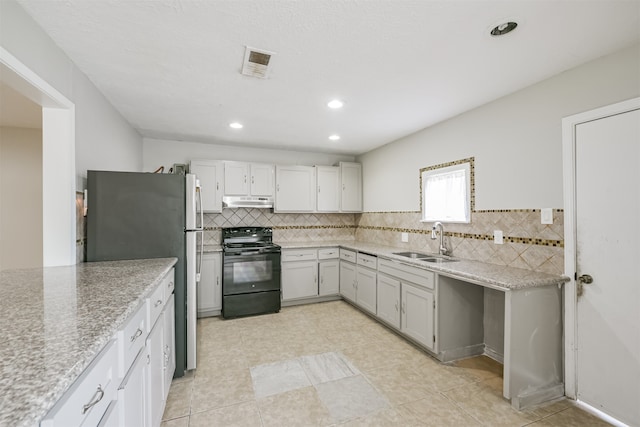 kitchen featuring stainless steel refrigerator, decorative backsplash, black electric range, and sink