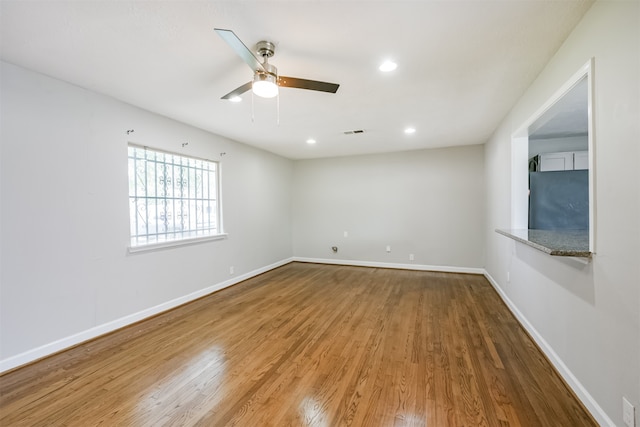 empty room with ceiling fan and hardwood / wood-style flooring