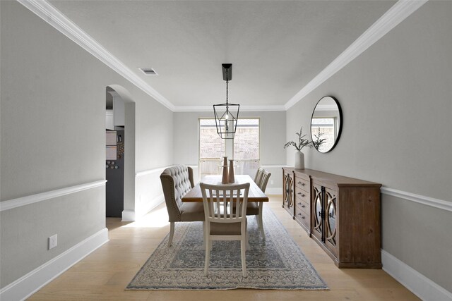 dining room featuring ornamental molding and light hardwood / wood-style floors