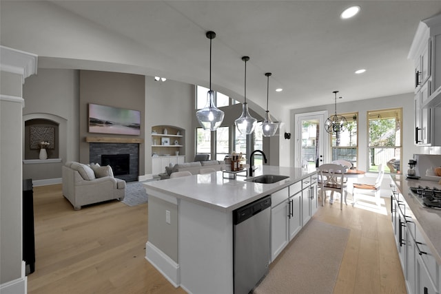 kitchen featuring stainless steel appliances, sink, white cabinets, and a kitchen island with sink