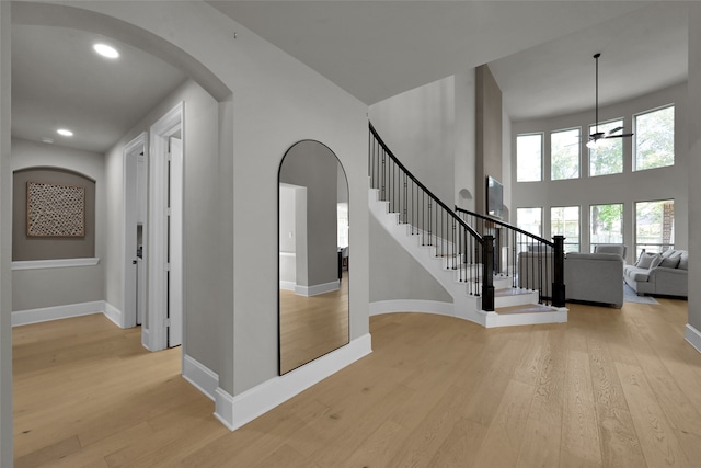 entrance foyer with light wood-type flooring, a high ceiling, and ceiling fan