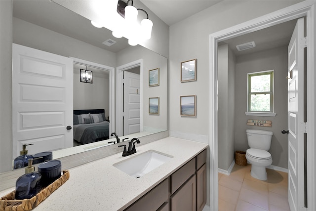 bathroom featuring vanity, toilet, an inviting chandelier, and tile patterned flooring