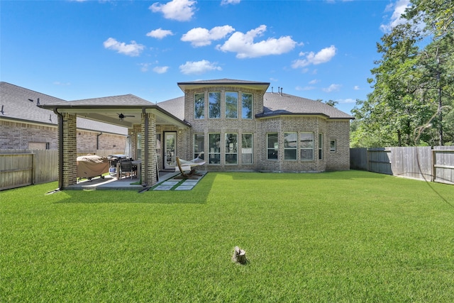 rear view of property featuring a lawn and a patio area