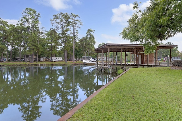 dock area with a lawn and a water view