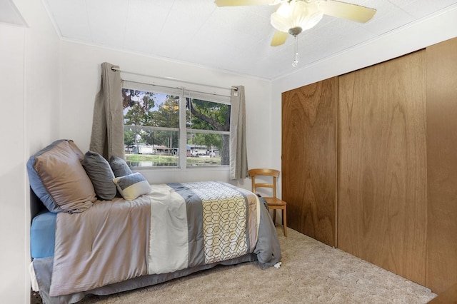 bedroom with carpet floors, ornamental molding, and a ceiling fan