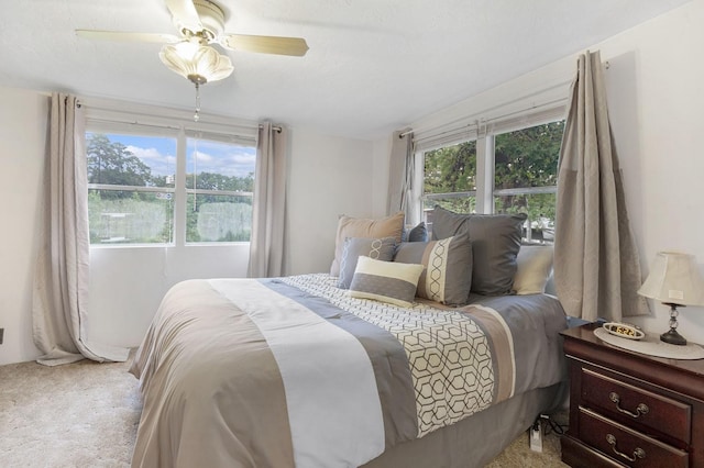 bedroom featuring carpet, multiple windows, and ceiling fan