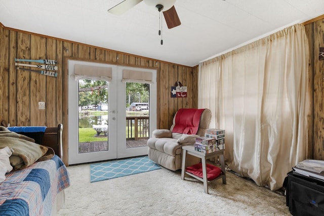 bedroom featuring access to outside, french doors, wooden walls, and carpet