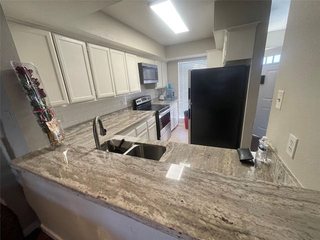 kitchen featuring white cabinetry, sink, fridge, kitchen peninsula, and stainless steel electric range