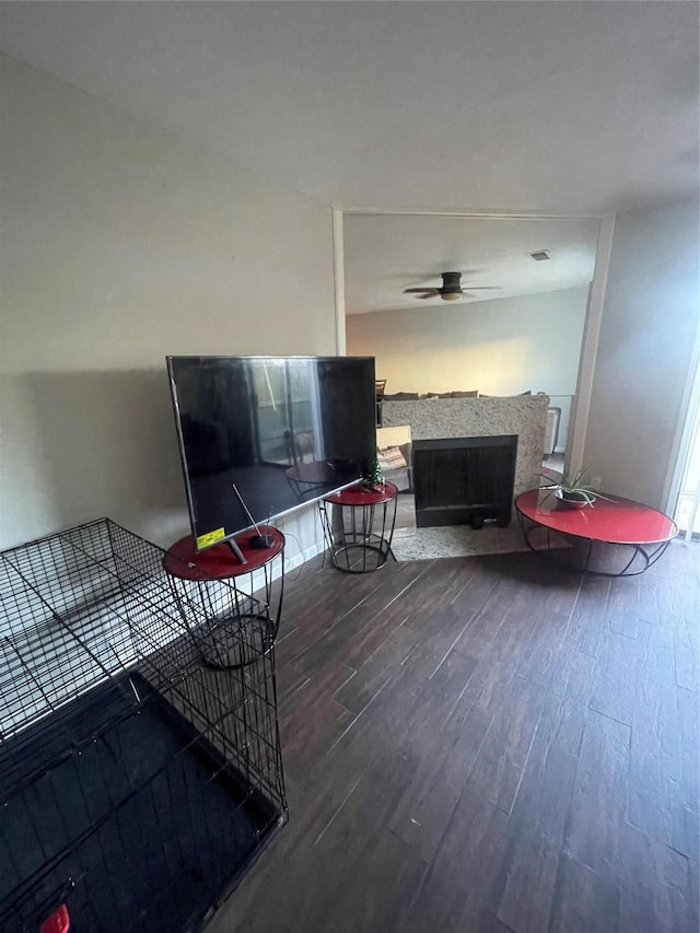 living room featuring dark wood-type flooring and ceiling fan