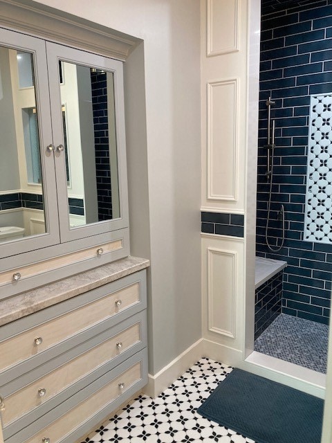 interior space with vanity and a tile shower