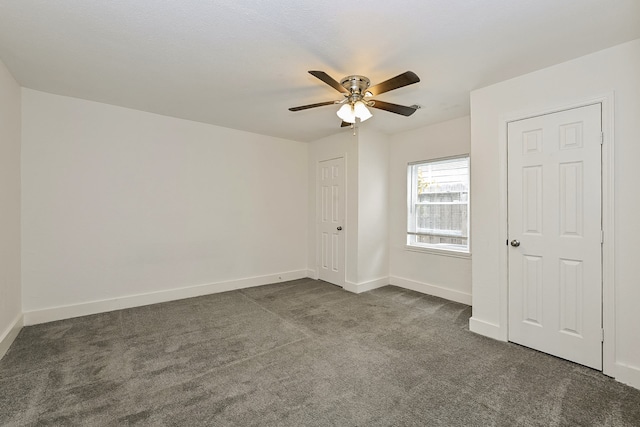 unfurnished bedroom featuring dark carpet and ceiling fan