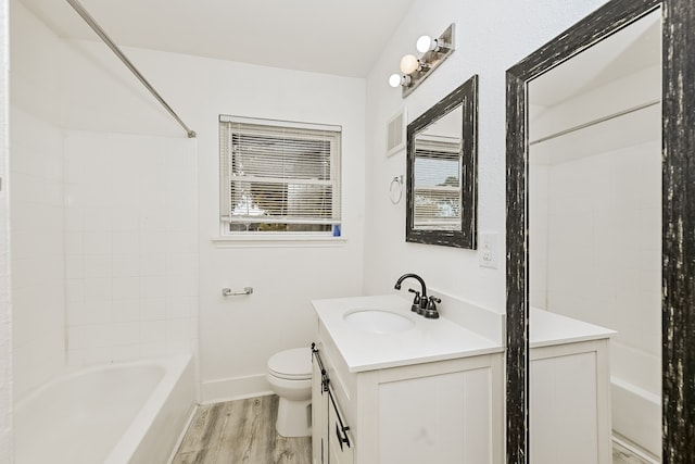 full bathroom with tiled shower / bath combo, vanity, toilet, and hardwood / wood-style flooring